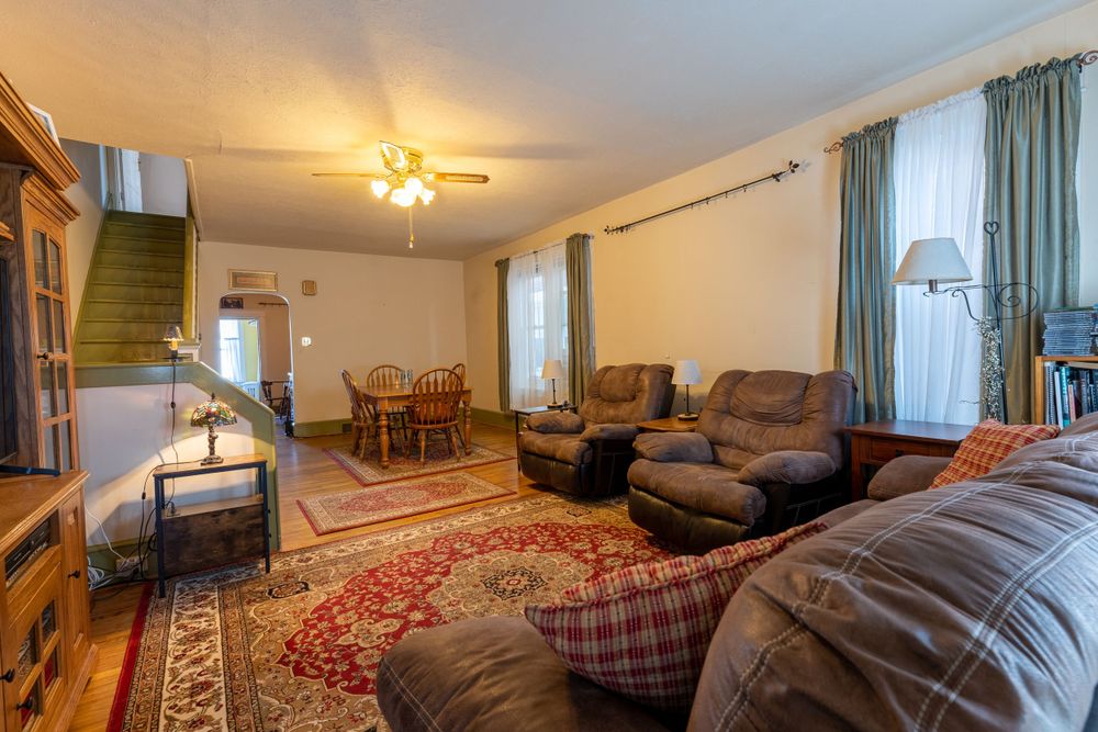 Spacious living area with comfortable sectional sofa, area rugs, and wooden dining set.