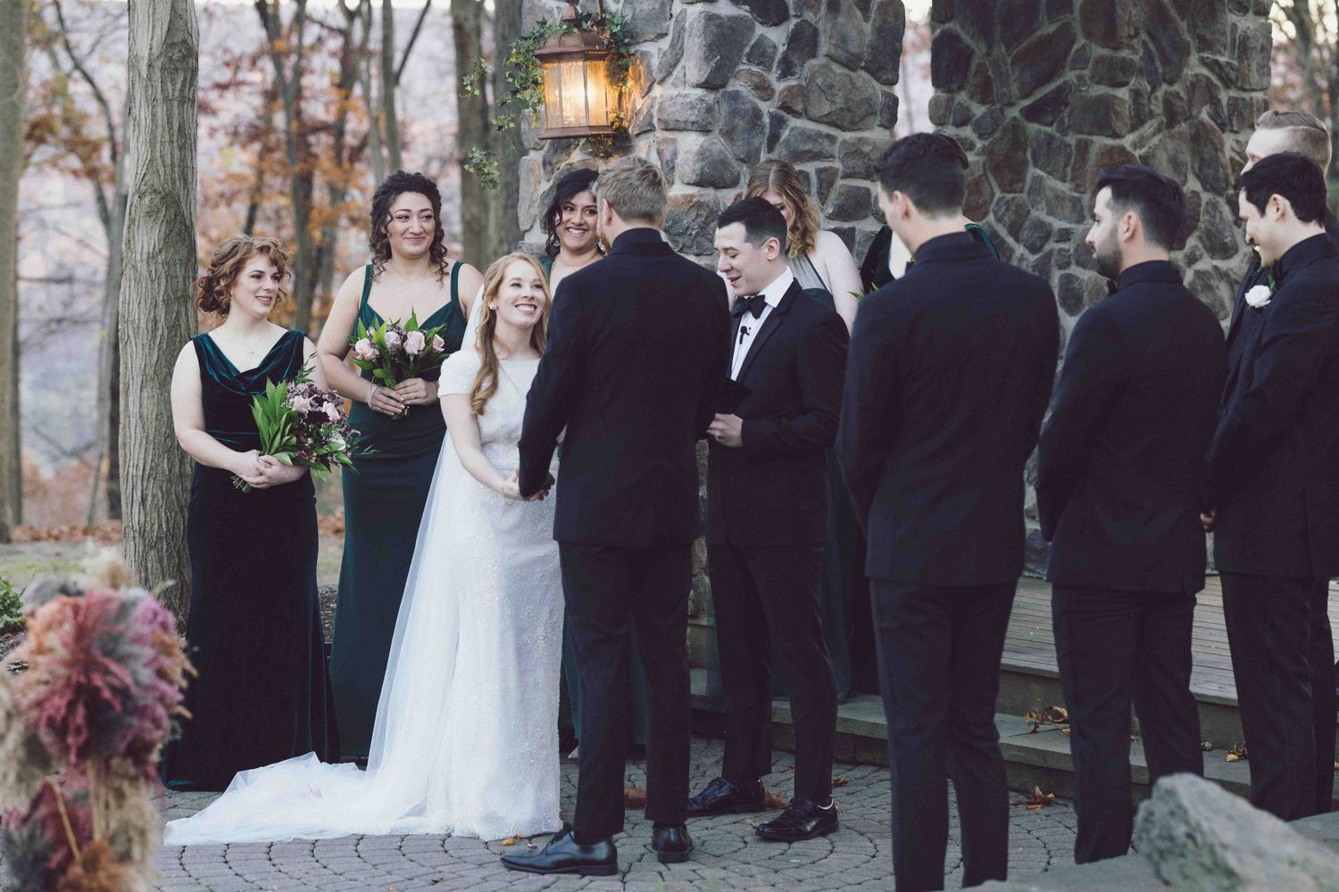 Outdoor winter wedding ceremony with wedding party in formal attire.