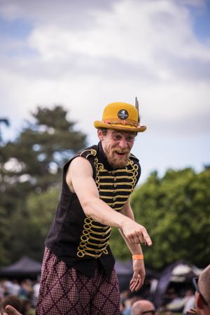 Festival imagery of man on stilts entertaining festival goers
