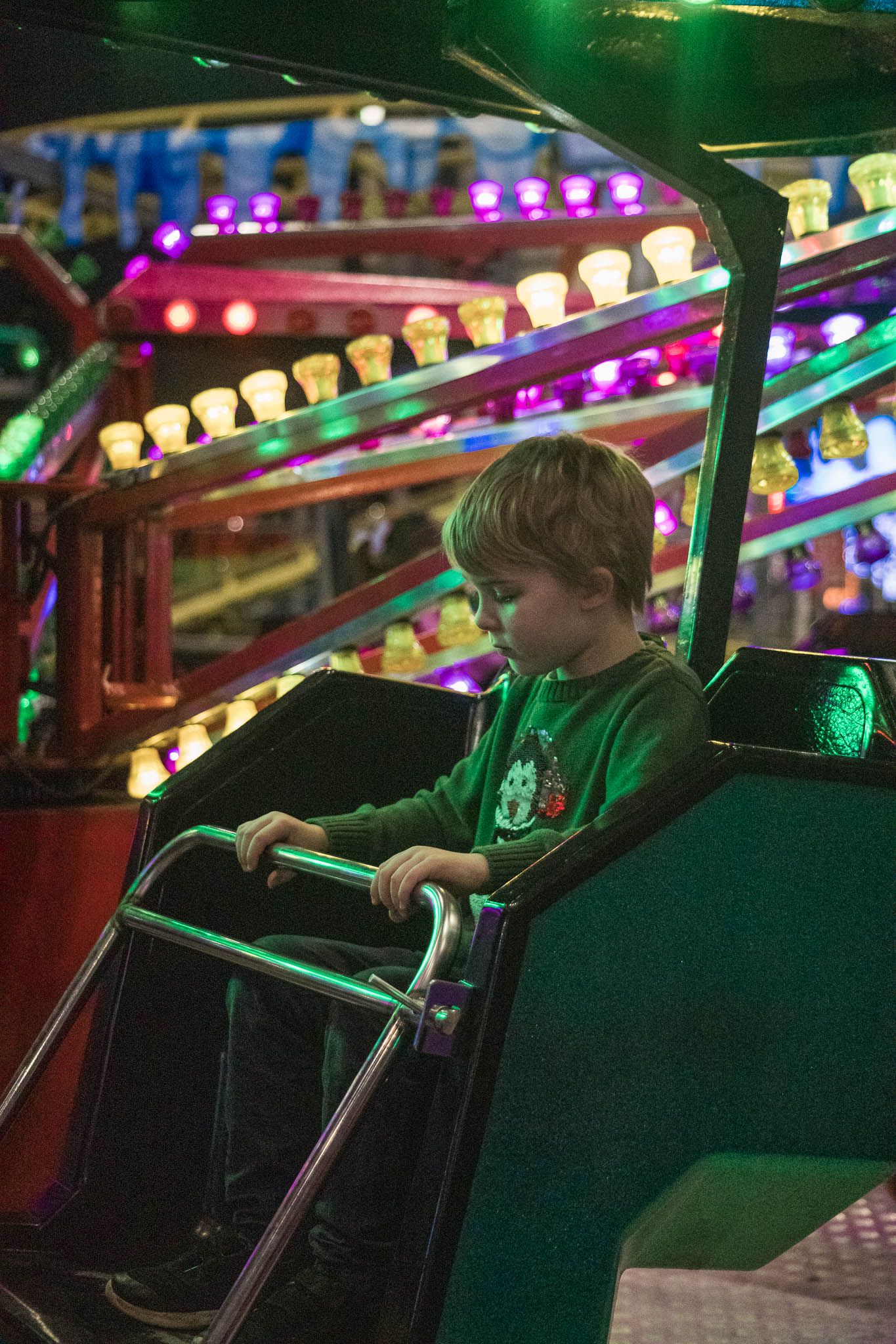 Image of child on a fairground ride wearing a Christmas jumper