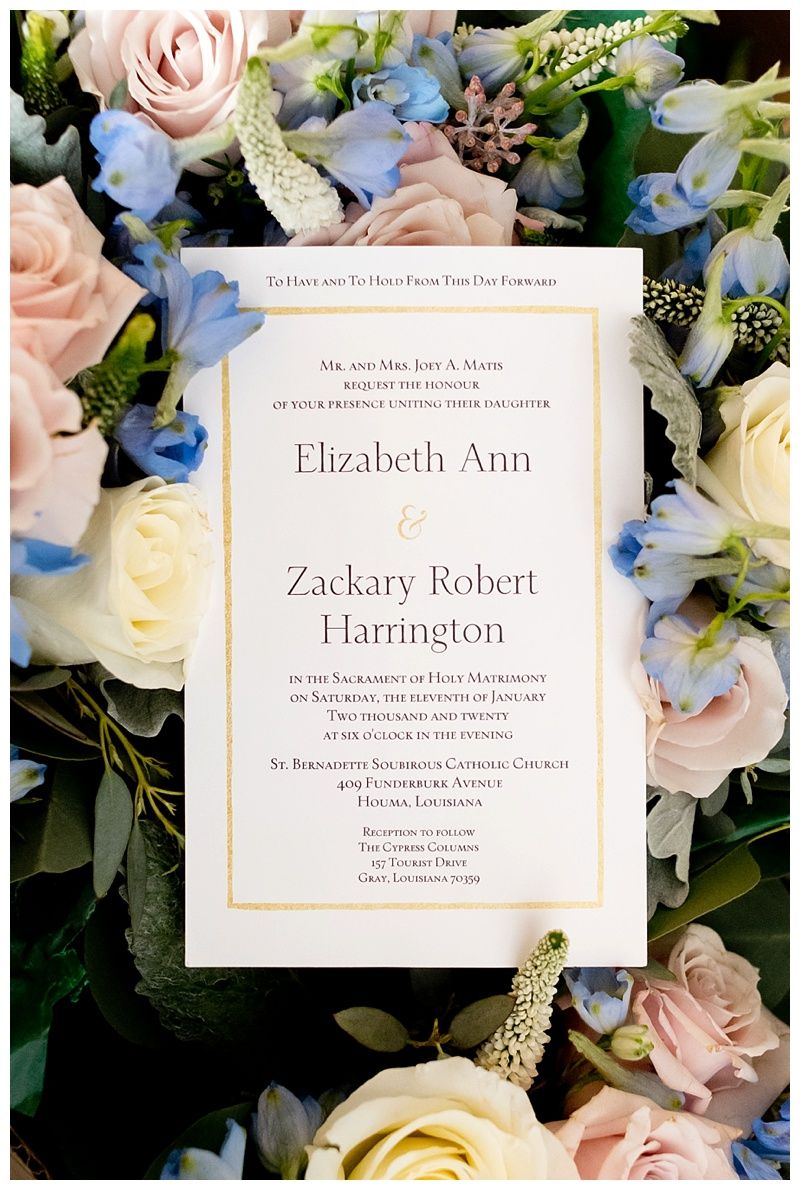 Wedding invitation suite with pink roses and blue flowers on black background.