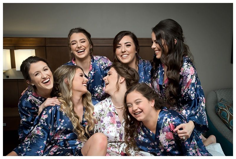 Wedding party members sharing joyful moments while getting ready.
