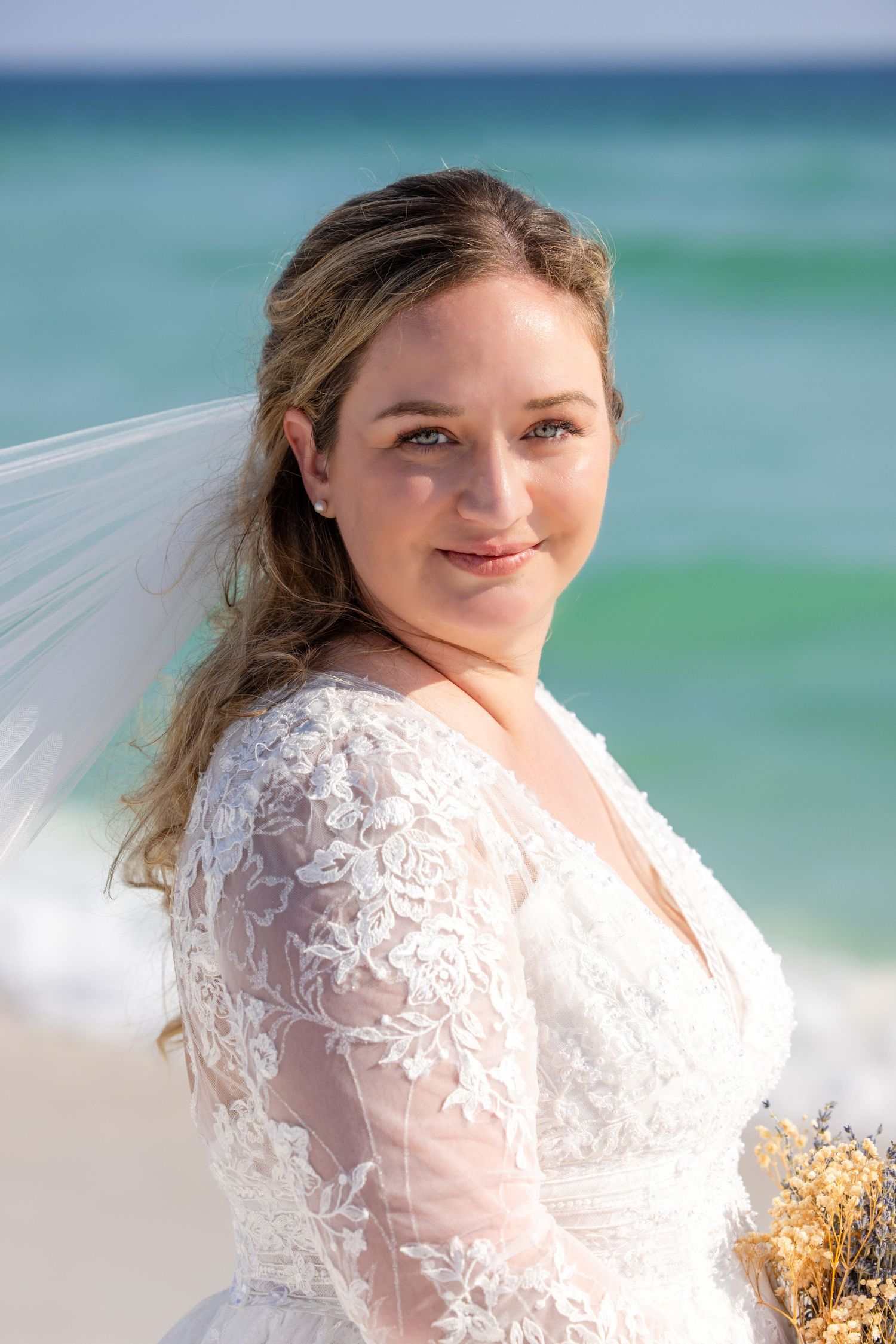 Bride portrait on beach with turquoise ocean background.