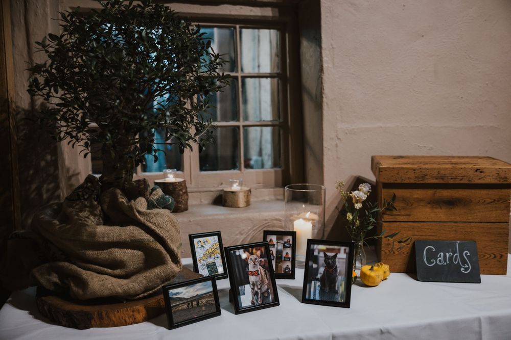 a display of photos in frames on a table at Pangdean barn during a wedding in Brighton
