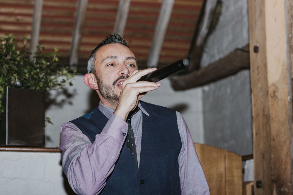 wedding guest holding microphone doing a speech to the newly weds in Pangdean Barn