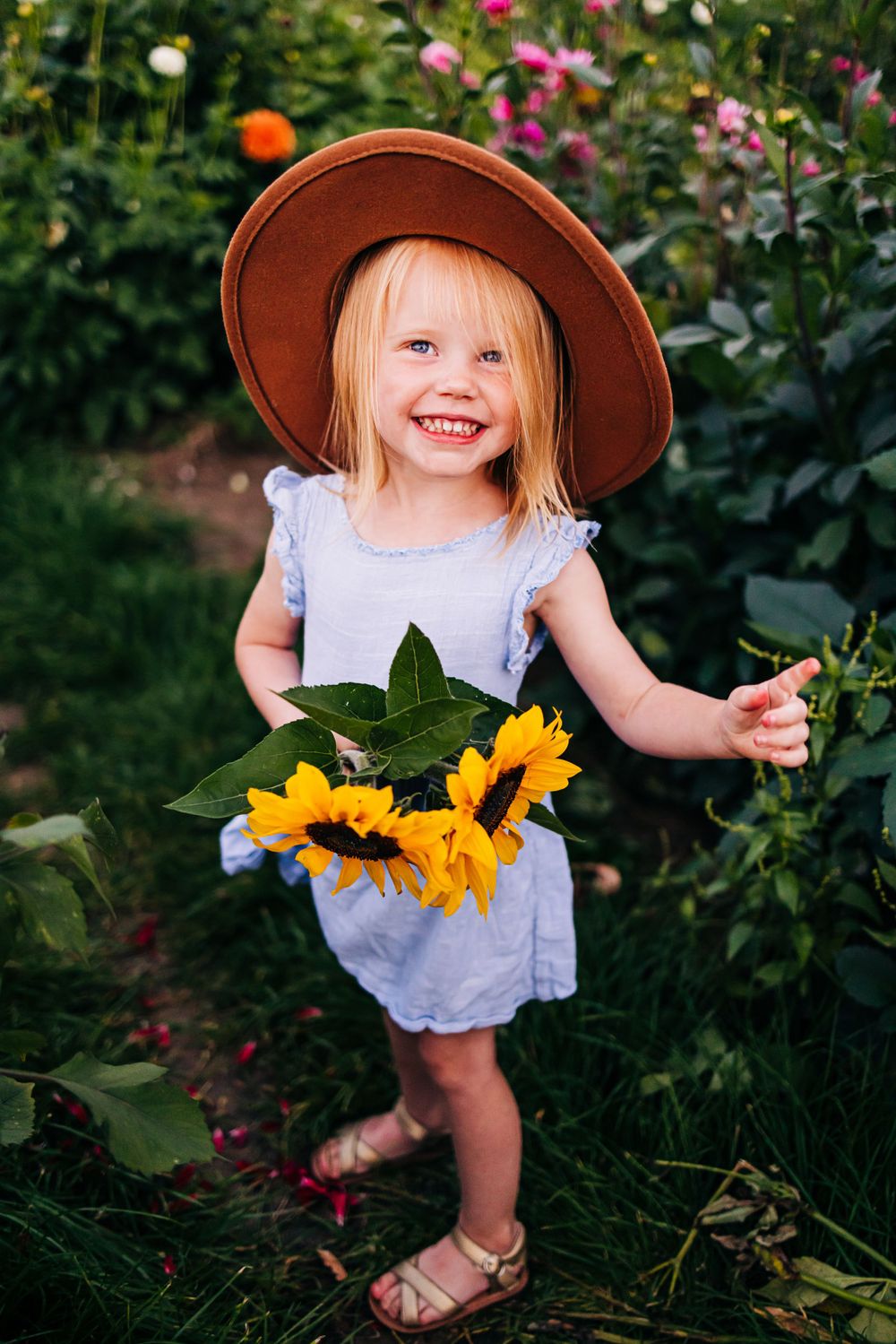 A whimsical garden scene with sunflowers and a blue dress on a summer day.