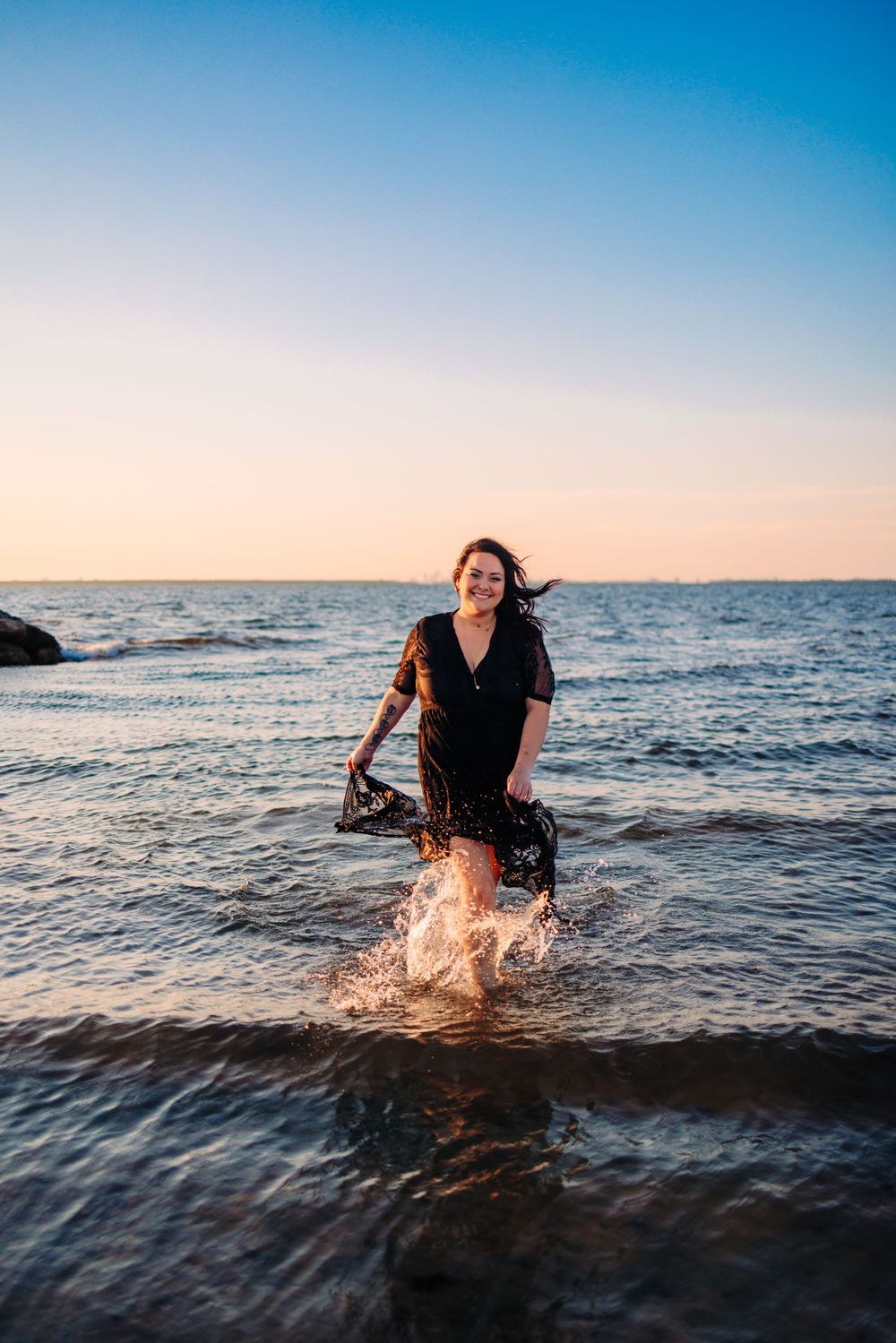 Dynamic action shot of someone splashing through ocean waves at sunset.