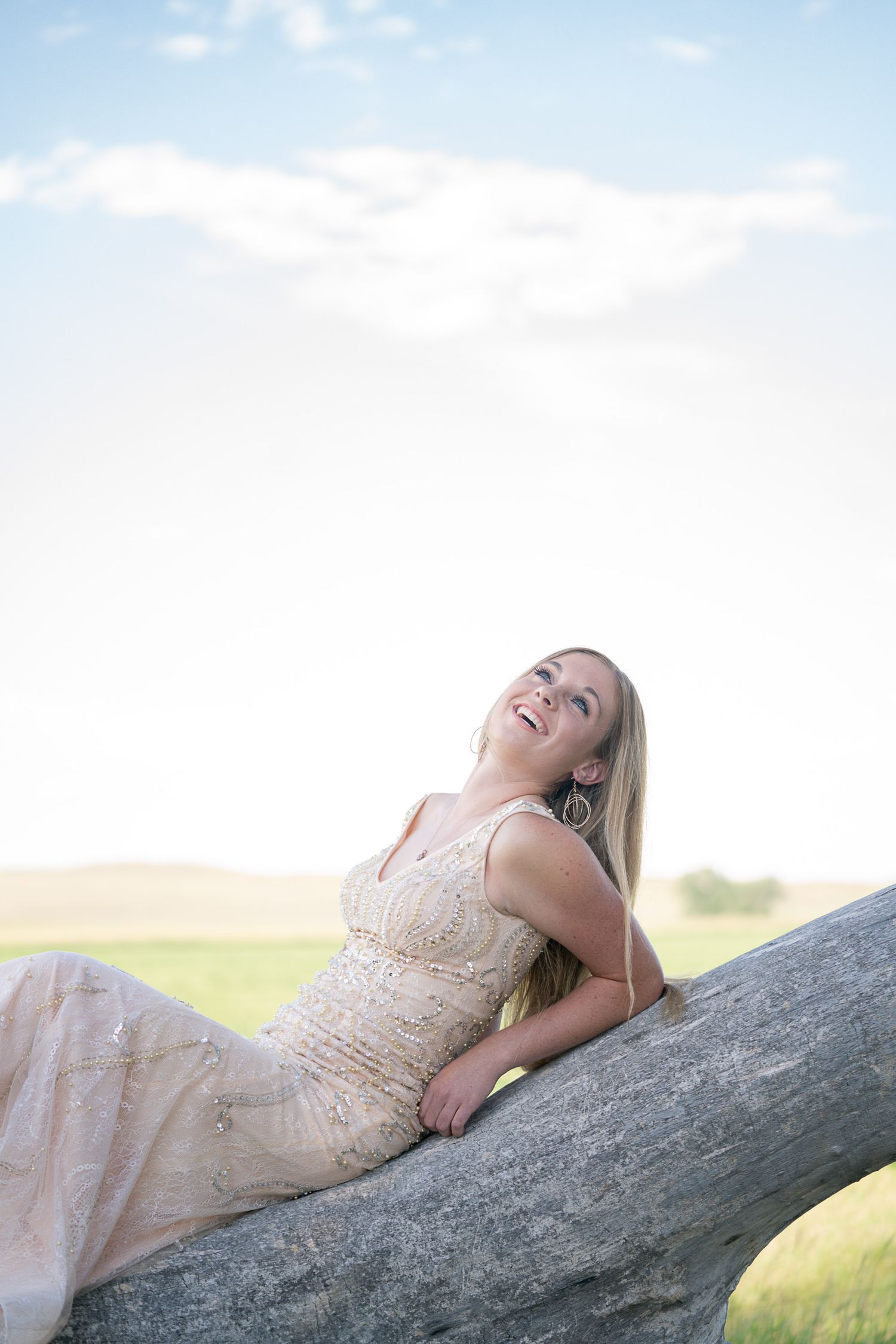 Dreamy outdoor portrait series on rock formation against bright sky.