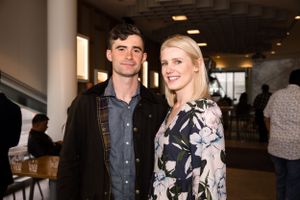 Two attendees smile while socializing at an indoor networking event.