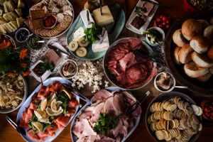 Overhead view of a feast spread with meats, cheeses, bread and various appetizers on platters.