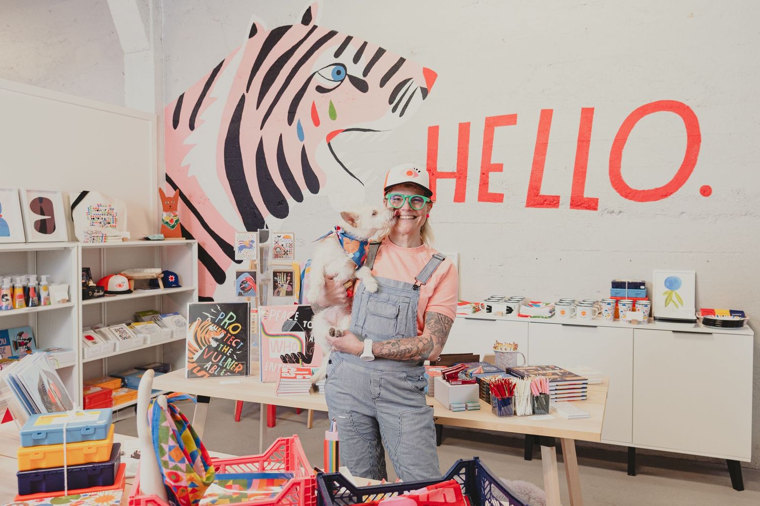 A retail space with bookshelves and a decorative wall featuring a stylized 'HELLO' design.