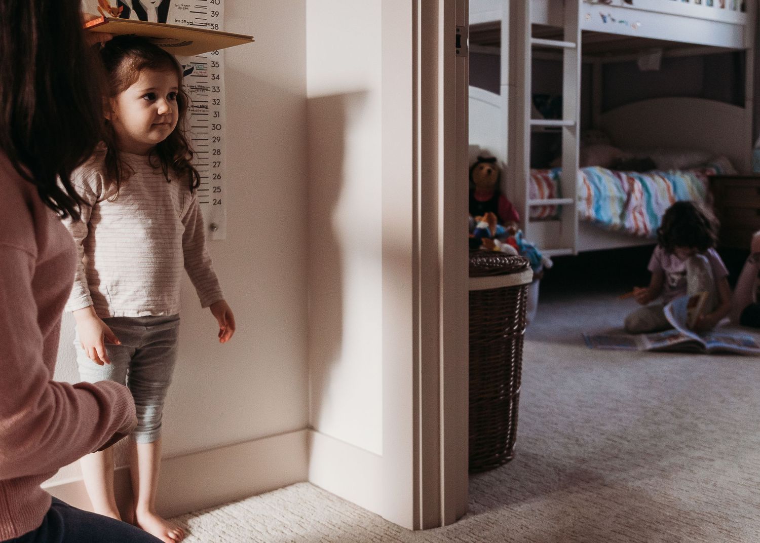 Indoor playtime scene through doorway with pink and natural lighting.