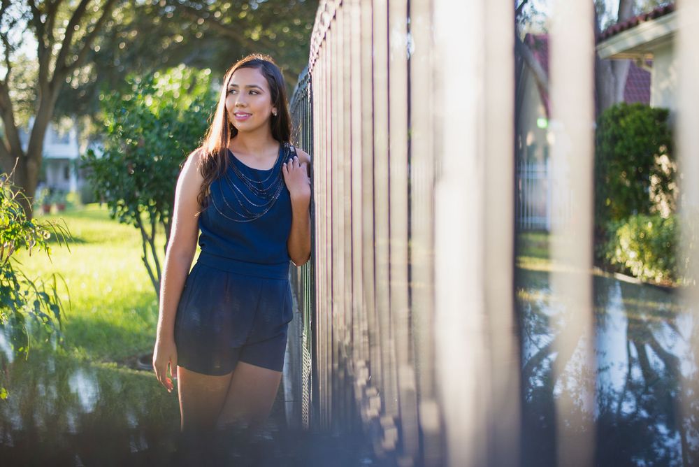 girl leaning on a fence looking away. quinceañera photo session. XV photographer