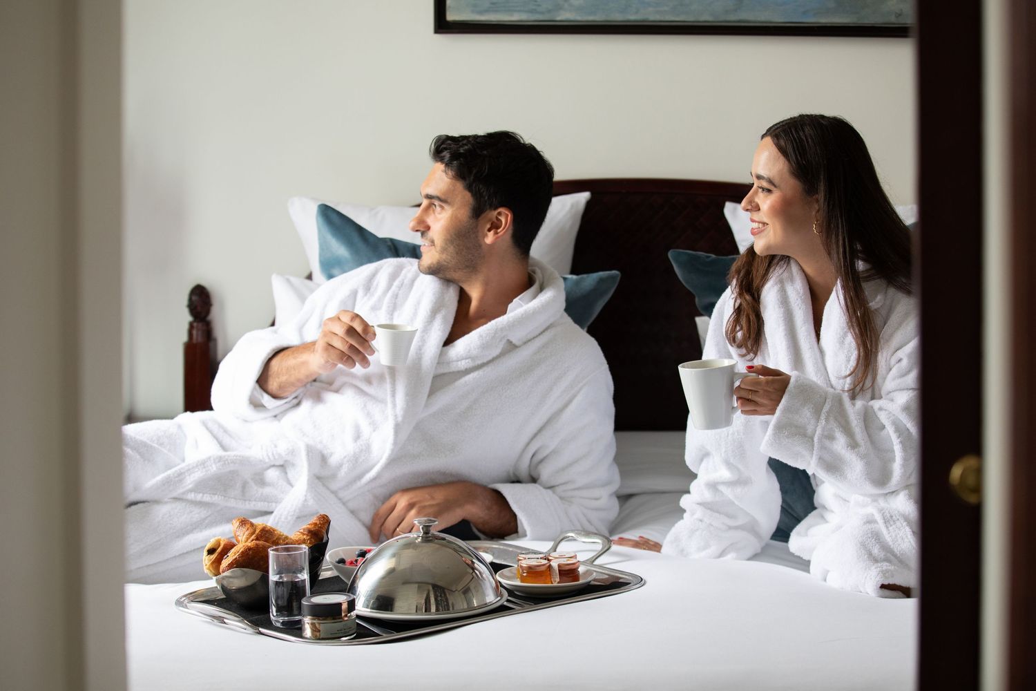 Luxurious breakfast in bed scene with room service tray in upscale hotel room.