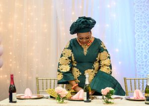 A guest in traditional African attire seated at an elegantly decorated dining table.