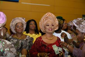 Group wearing colorful traditional African attire celebrating at formal event.