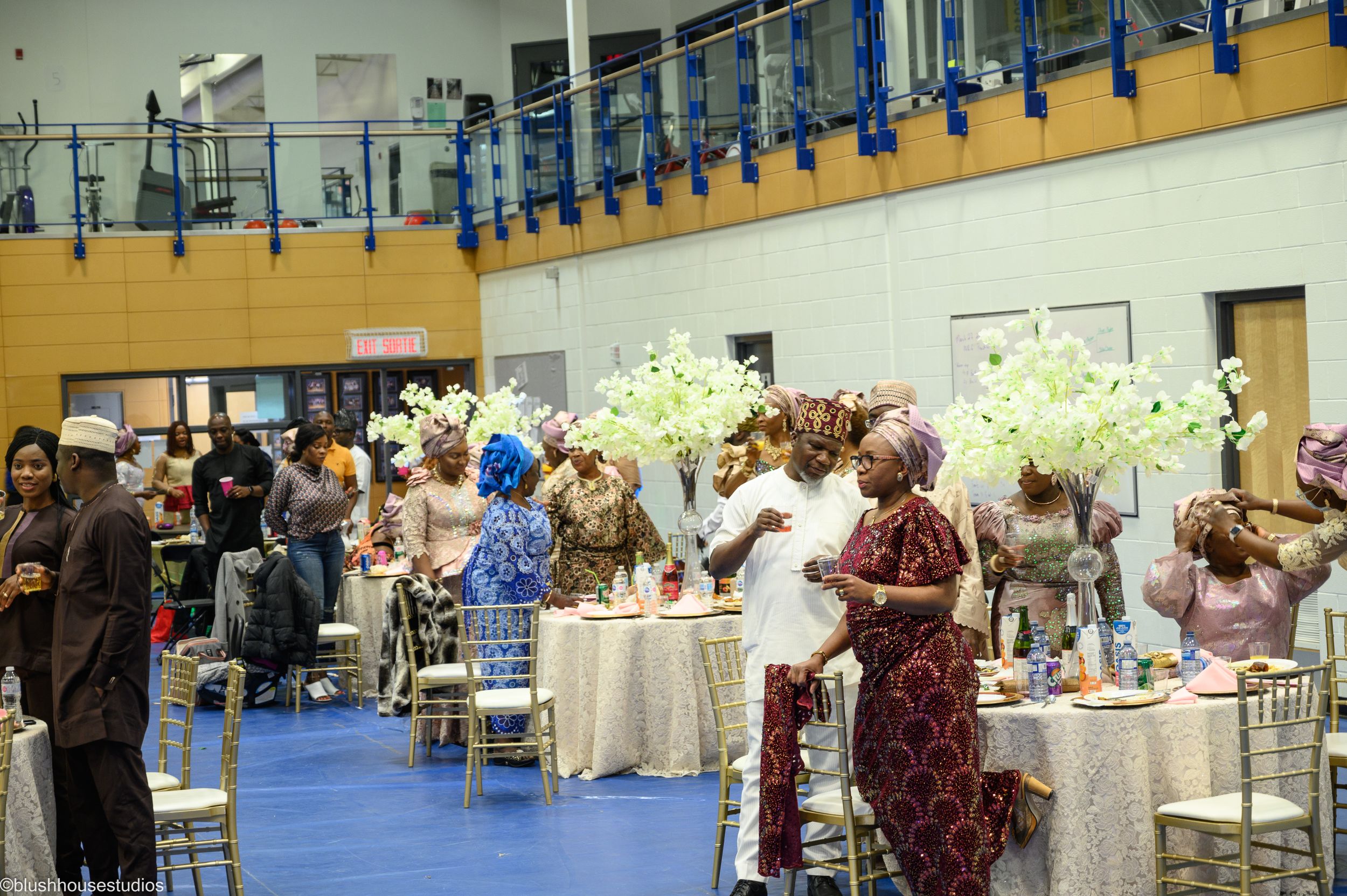 Event space with decorated tables and guests mingling in formal attire.