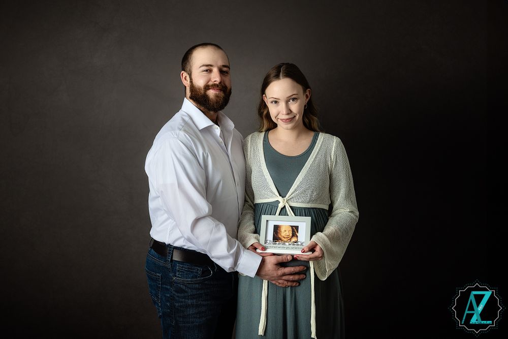 Couple holds ultrasound photo together during studio maternity session.