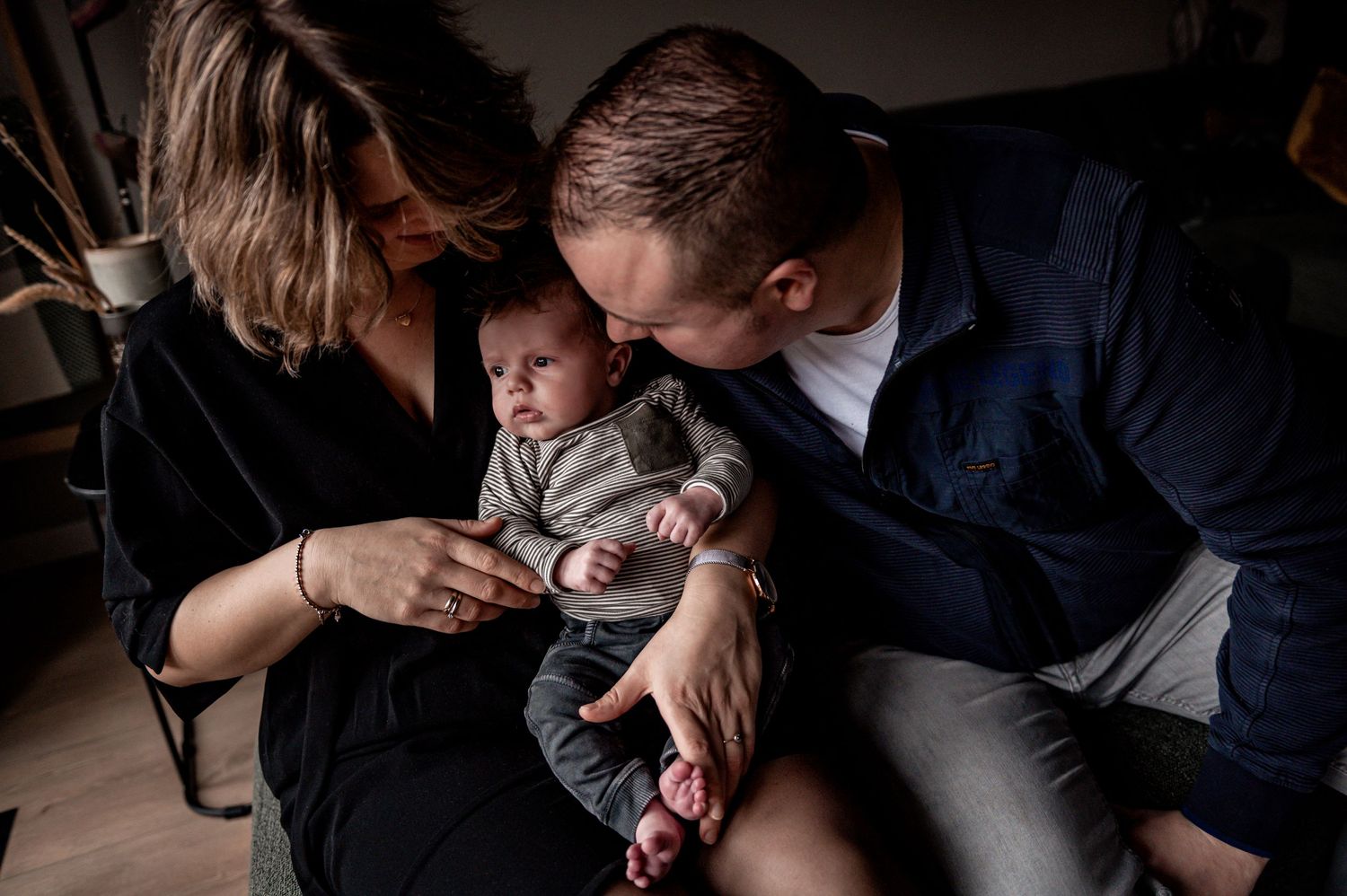 Intimate black and white family moment captured in low light setting.