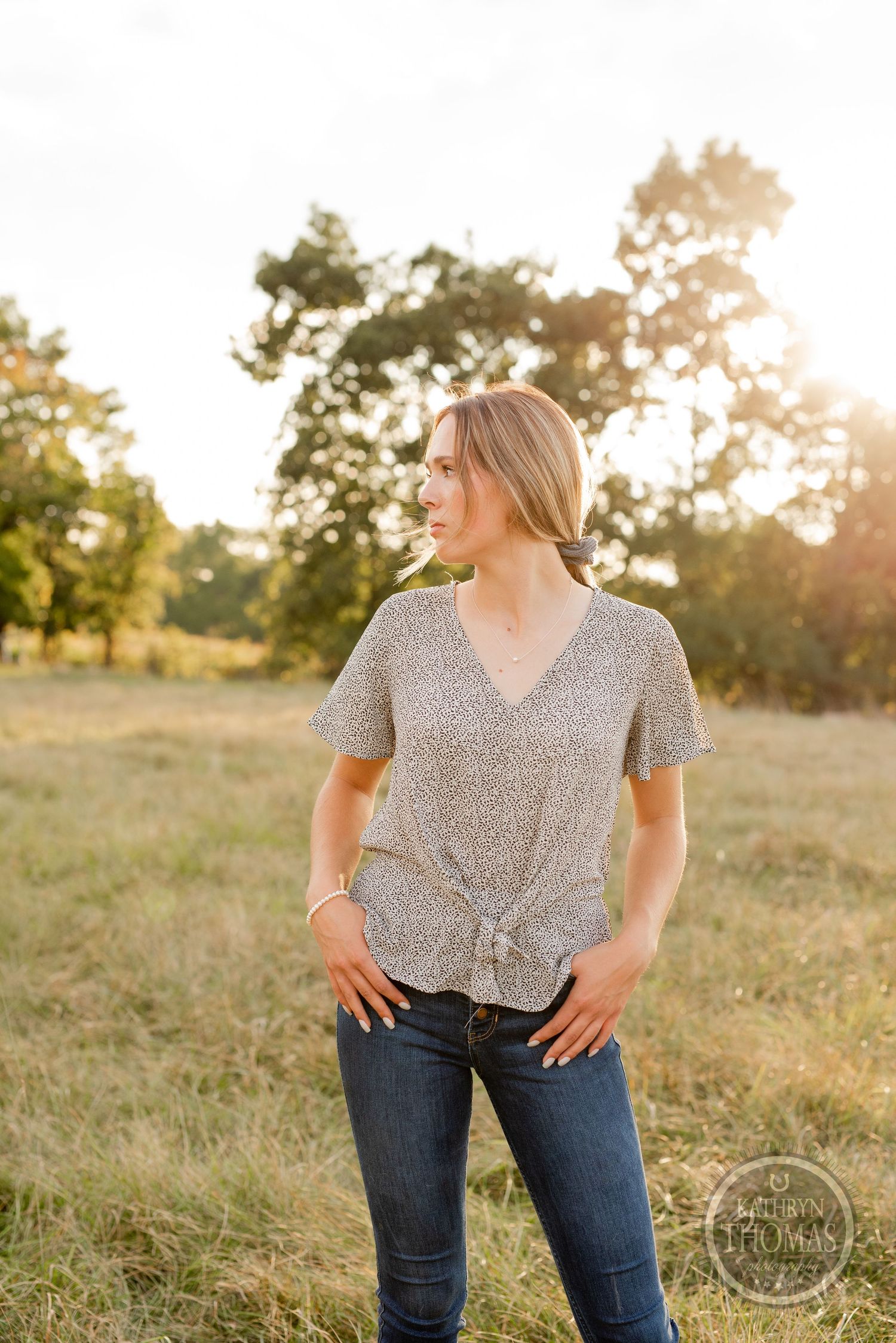 Casual outdoor portrait wearing gray patterned top in golden evening light.