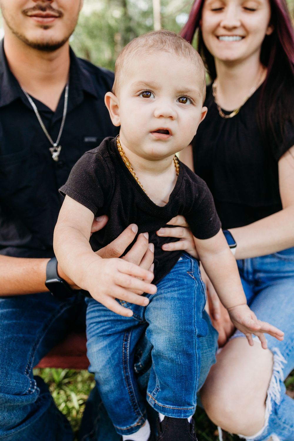 Close-up outdoor family portrait on a rustic bench.