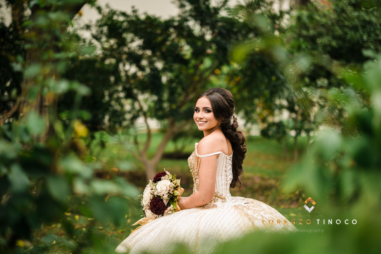 A romantic garden portrait featuring a flowing white ballgown dress amidst lush greenery.
