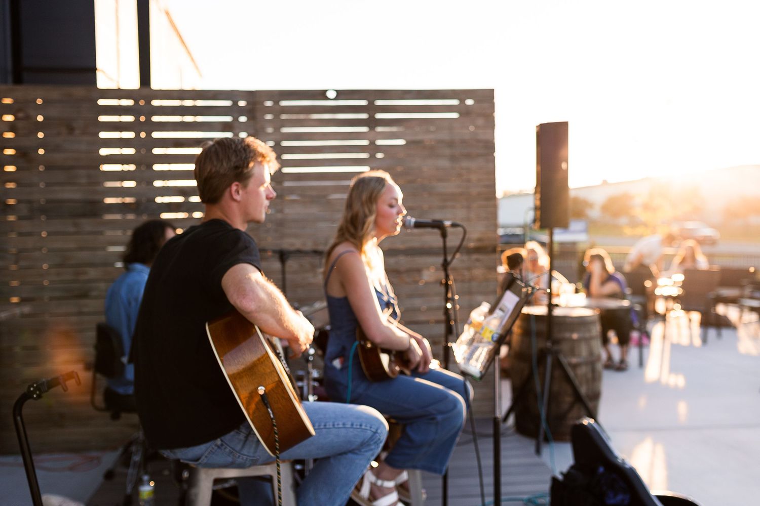 A band playing at a brewery in St. Cloud, MN while a golden sunset highlights them.
