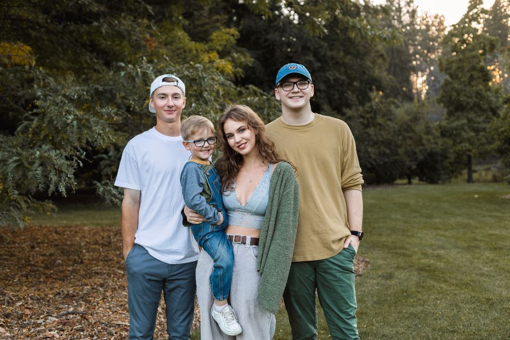 Casual group photo of family members standing together outdoors in autumn setting.