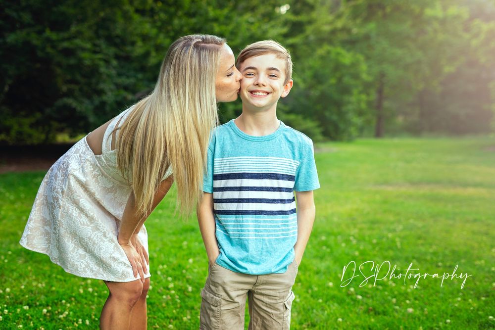 A sweet outdoor portrait moment with green summer scenery in the background.