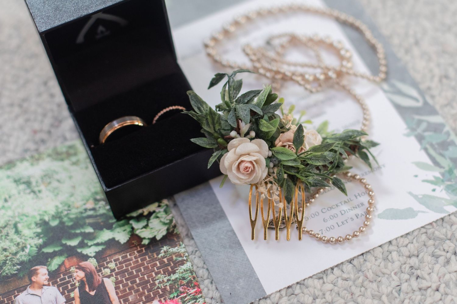 Wedding accessories and jewelry arranged with floral elements on a light surface.