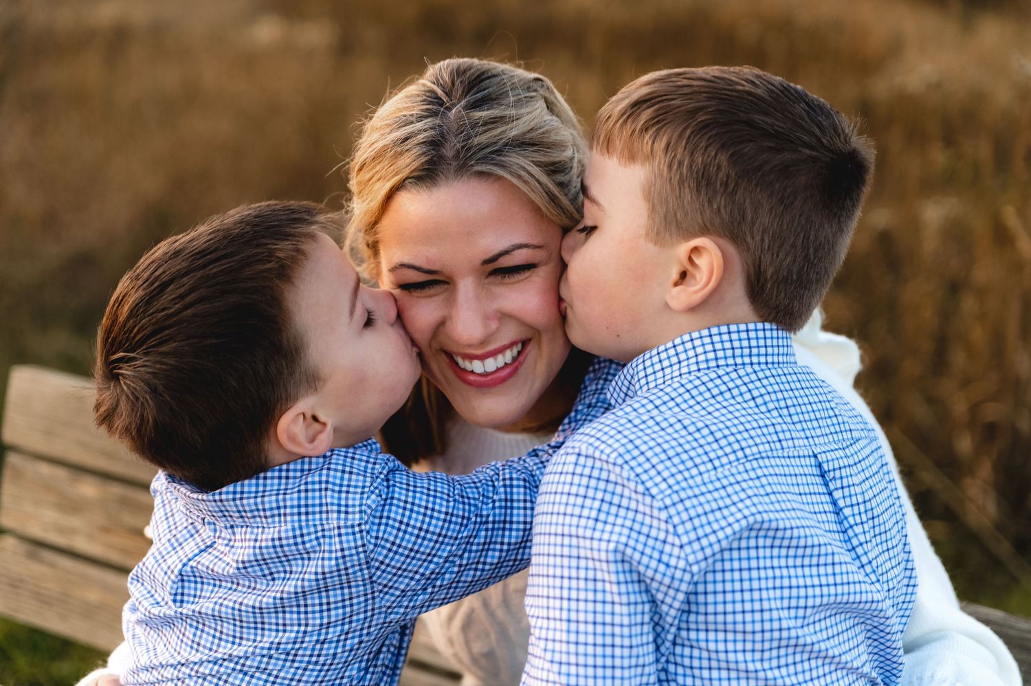 Sweet moment captured of family members sharing affection and laughter outdoors.