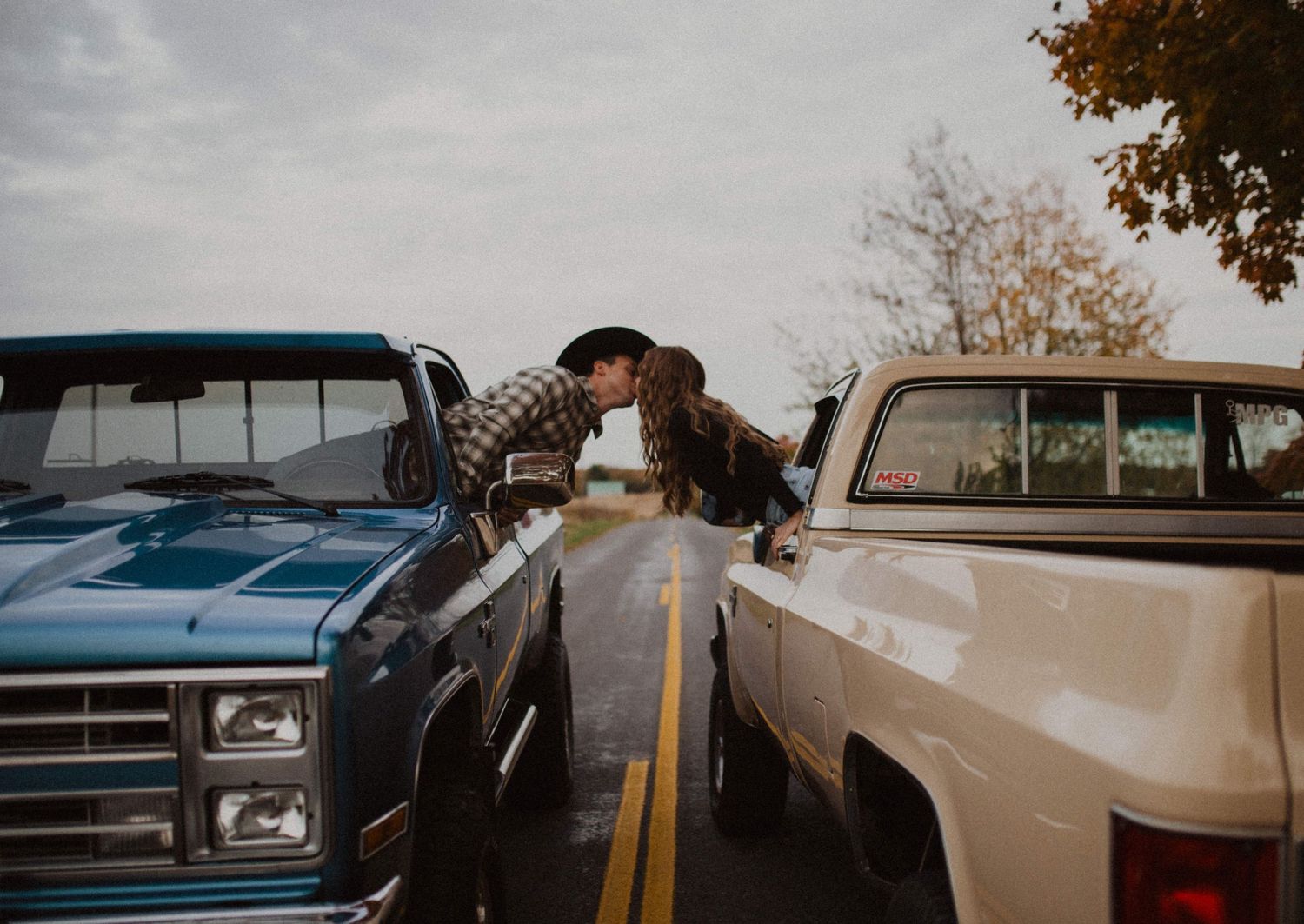 Couple kissing from the window of vintage square body trucks southwest michigan