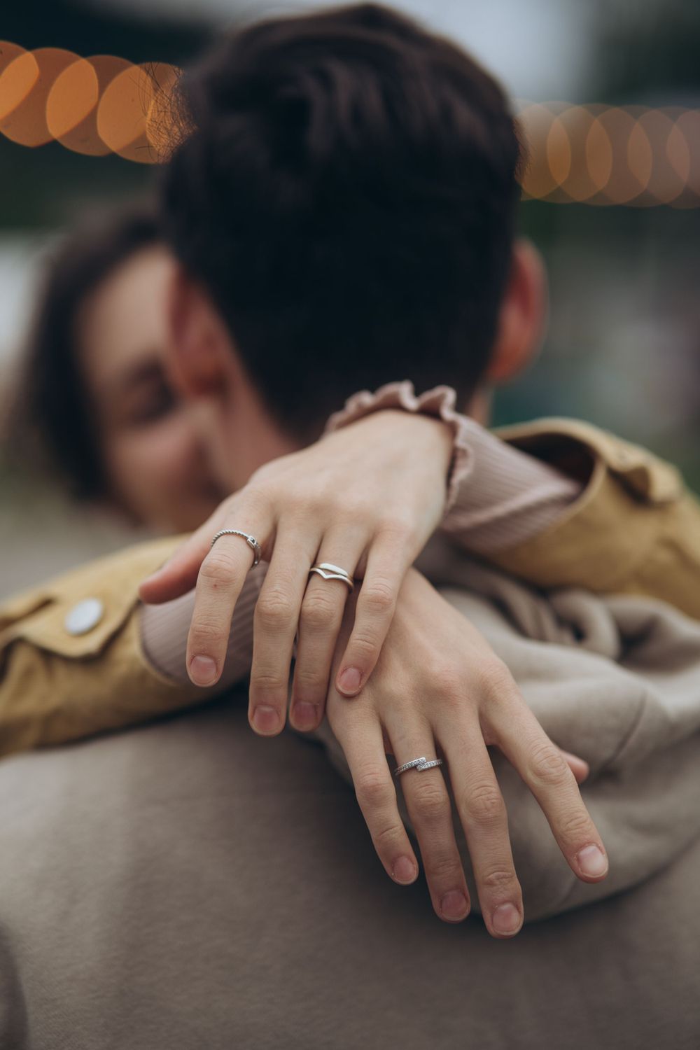 Close-up of hands with matching wedding rings in an intimate embrace.