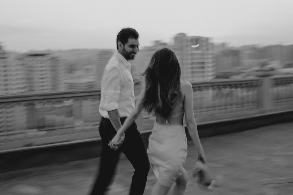 Couple dancing together on urban rooftop in black and white photography.