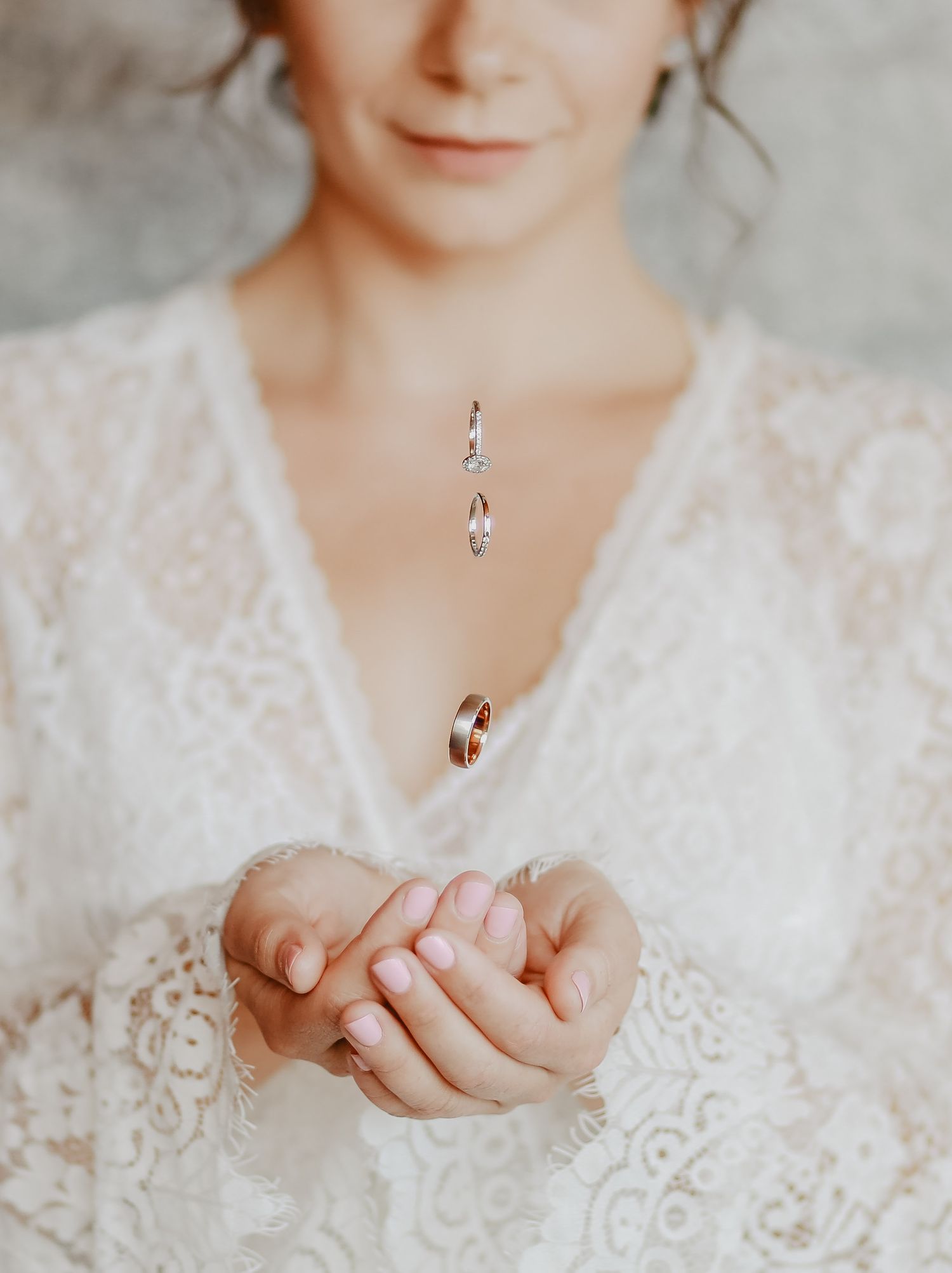 Delicate bridal jewelry and lace details with hands gently cupped.