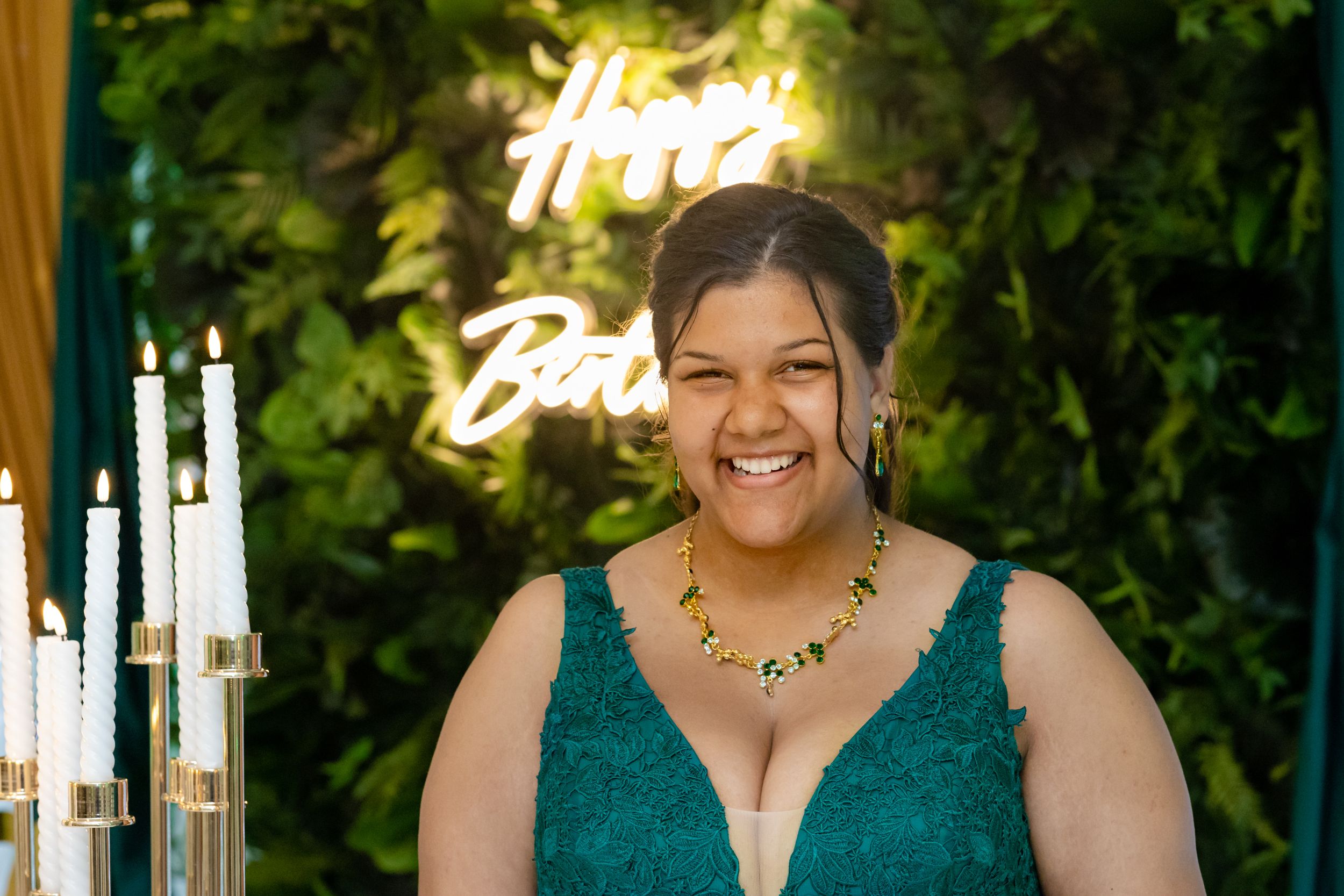 Festive gathering with emerald green decor and warm lighting against a botanical backdrop.