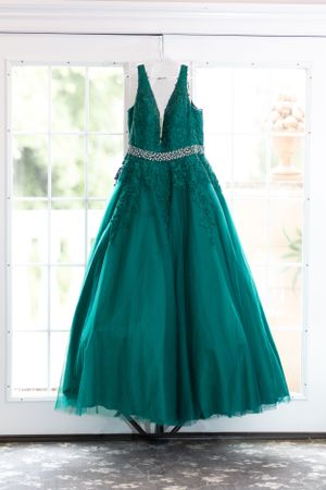 Multiple views of an elegant teal tulle gown with crystal embellishments displayed in a bright studio setting.