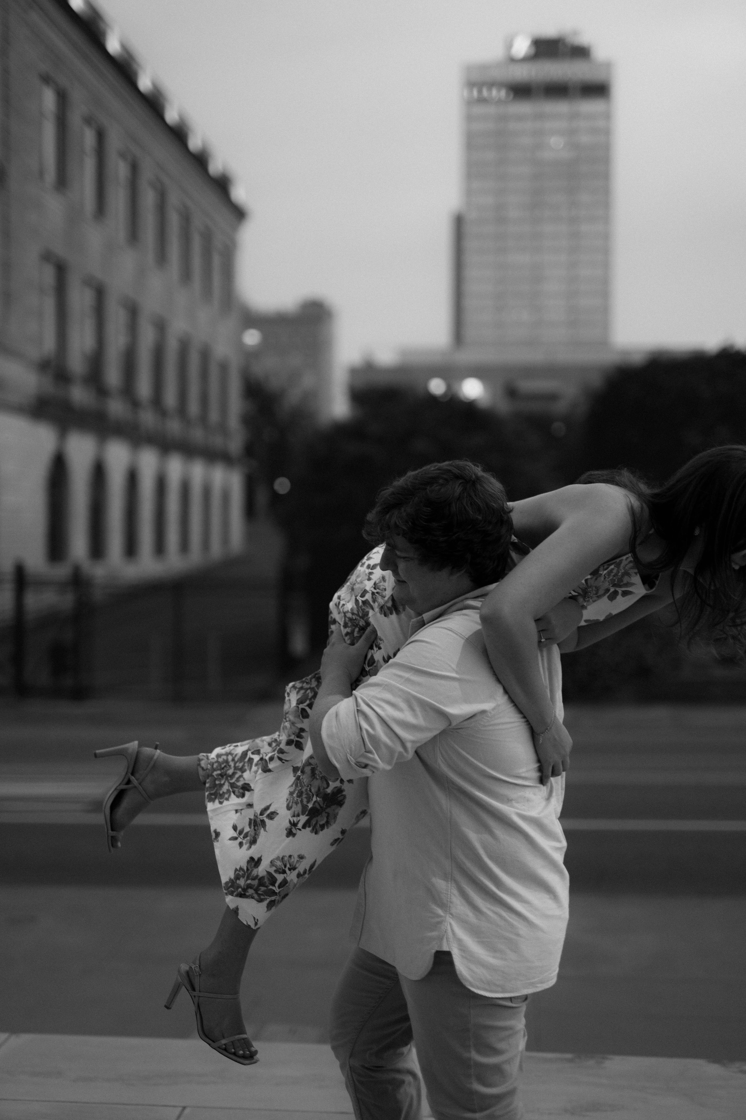 Dynamic sequence showing a playful moment between a couple near an urban building at dusk.