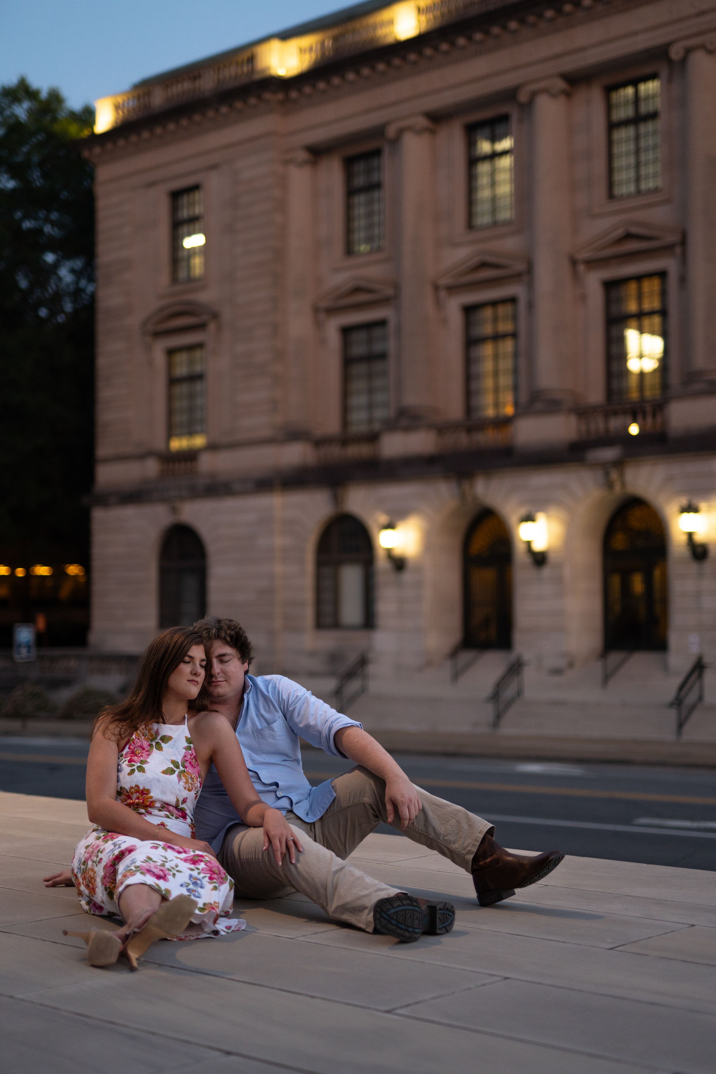 Romantic evening scene with a couple resting on stone steps of a grand building.