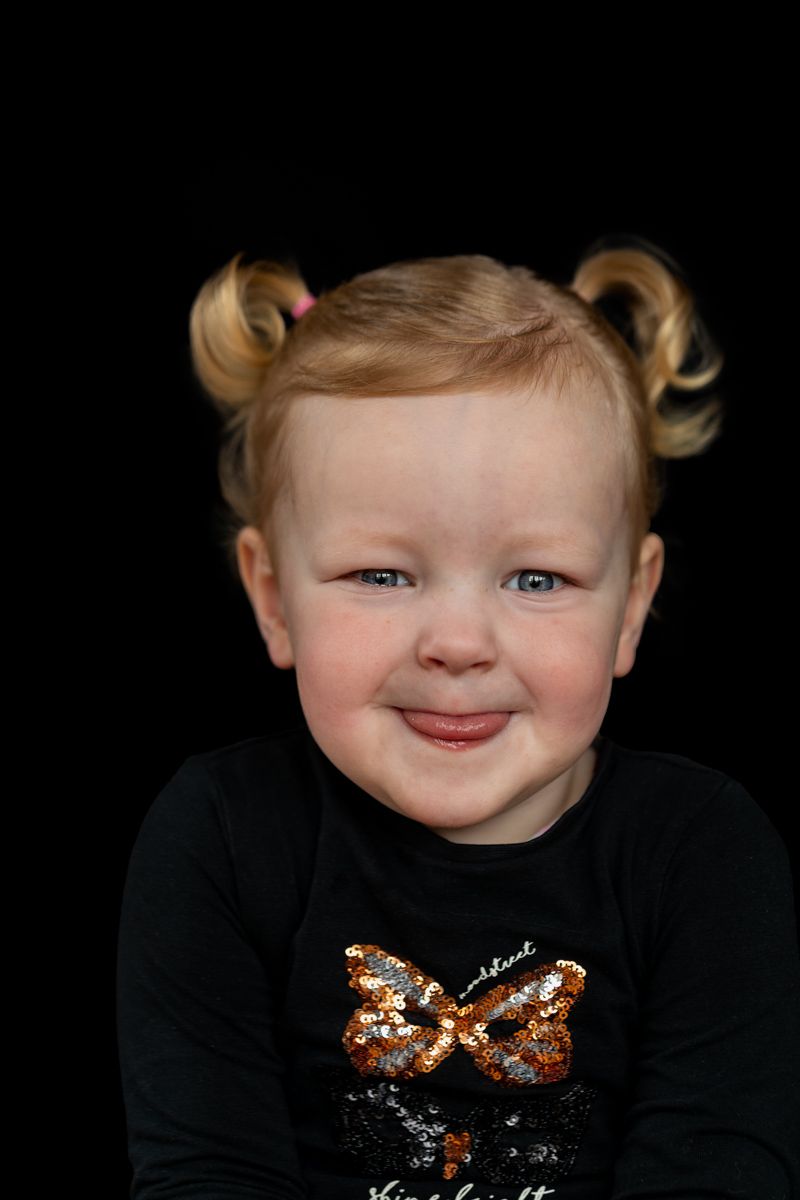 Barbara Kempeneers Fotografie, Kinderportret, ondeugend meisje met tong uitsteken