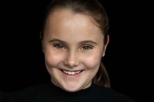 Barbara Kempeneers Fotografie, Kinderportretten, Portret van een mooi meisje tegen een zwarte achtergrond