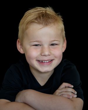 Kinderportret stoere jongen tegen zwarte achtergrond, Kinderportetfotografie, Barbara Kempeneers Fotografie