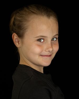 Kinderportret lachend meisje tegen zwarte achtergrond, Kinderportetfotografie, Barbara Kempeneers Fotografie