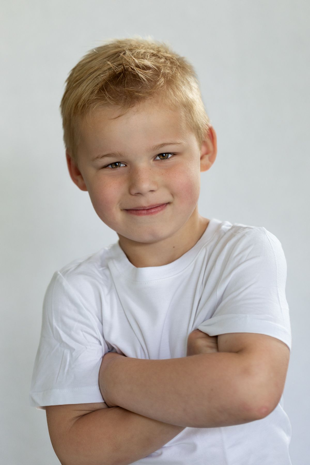 Kinderportret jongen met armen overelkaar tegen witte achtergrond, Kinderportetfotografie, Barbara Kempeneers Fotografie