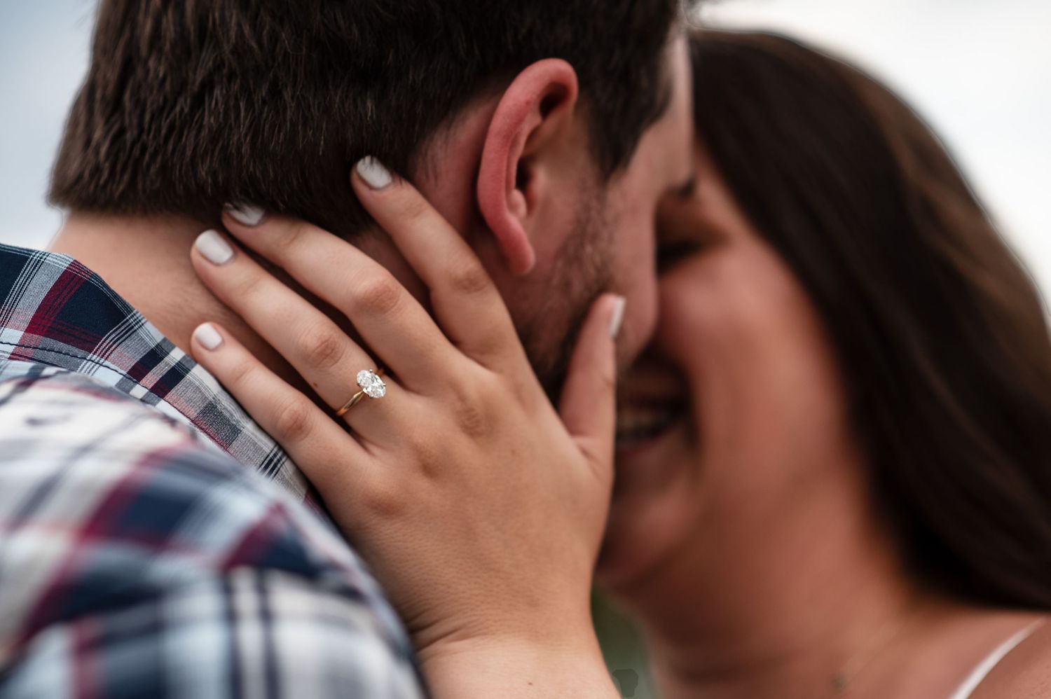 Close-up of engagement ring as couple shares intimate moment.
