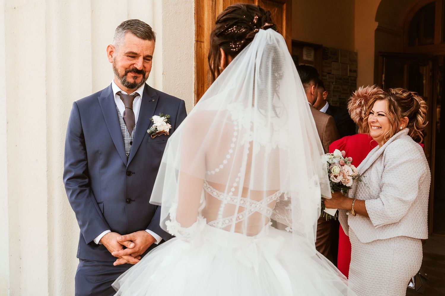 A wedding couple share a tender moment during their ceremony as attendants look on.