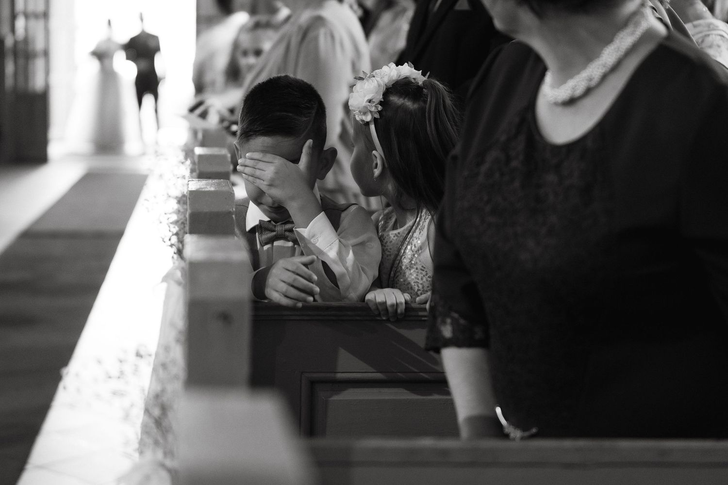 A black and white candid moment captured during a wedding ceremony.