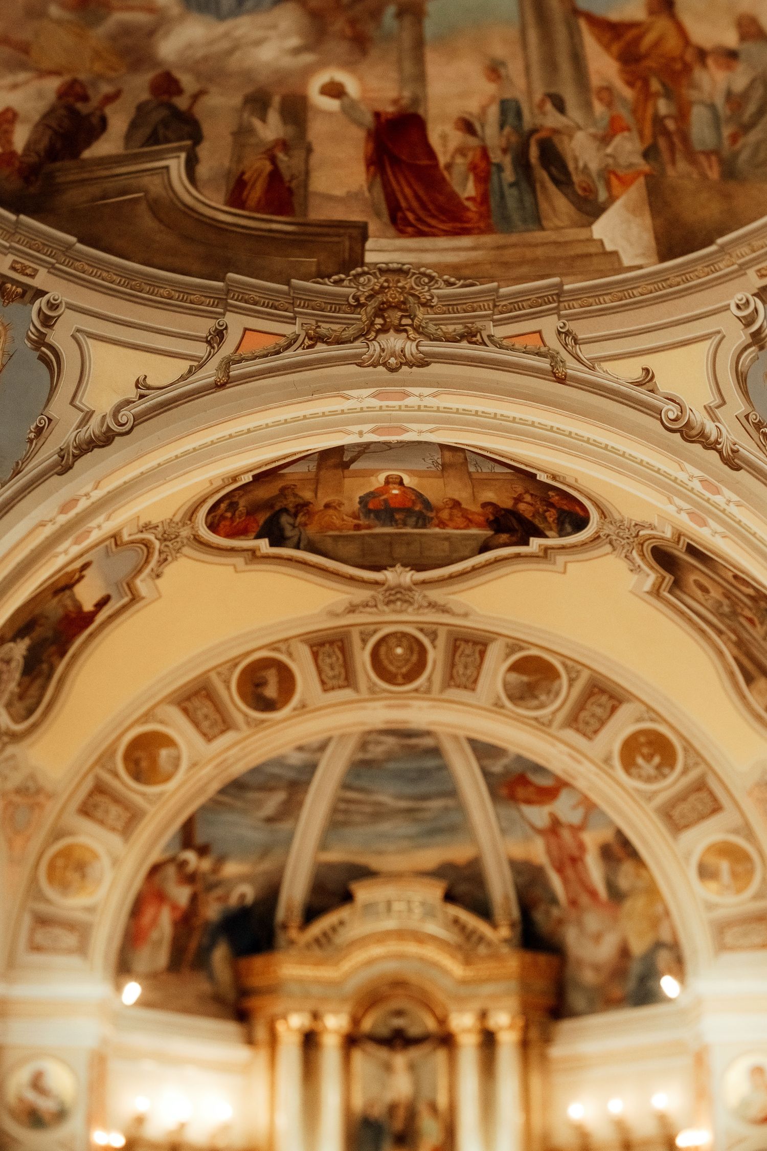 Ornate church ceiling featuring detailed religious frescoes and architectural elements.