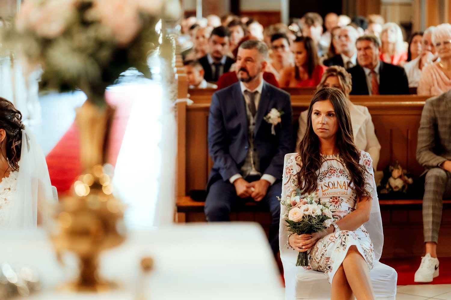 Wedding ceremony taking place in an ornate church with guests filling the pews.