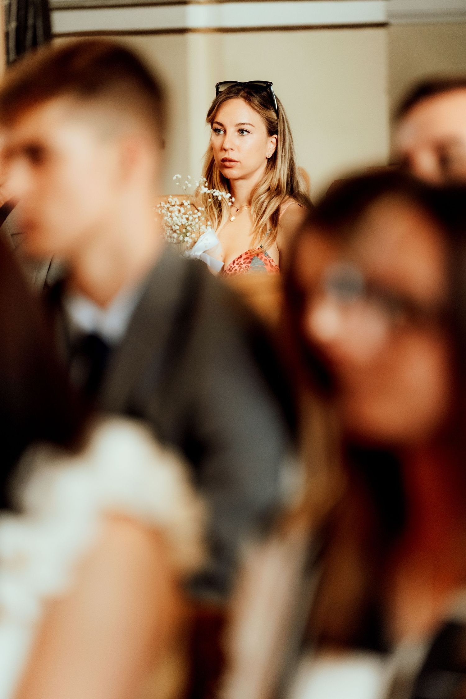 Guest watching wedding ceremony in soft focus with dreamy lighting.